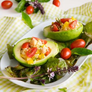 Avocados mit Couscous und Gemüse serviert auf einen Teller